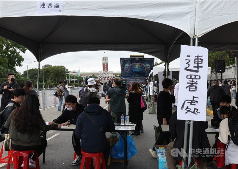 People sign a petition to the government in one of the tents set up by the organizers of the demonstration in Taipei Sunday. CNA photo Dec. 3, 2023