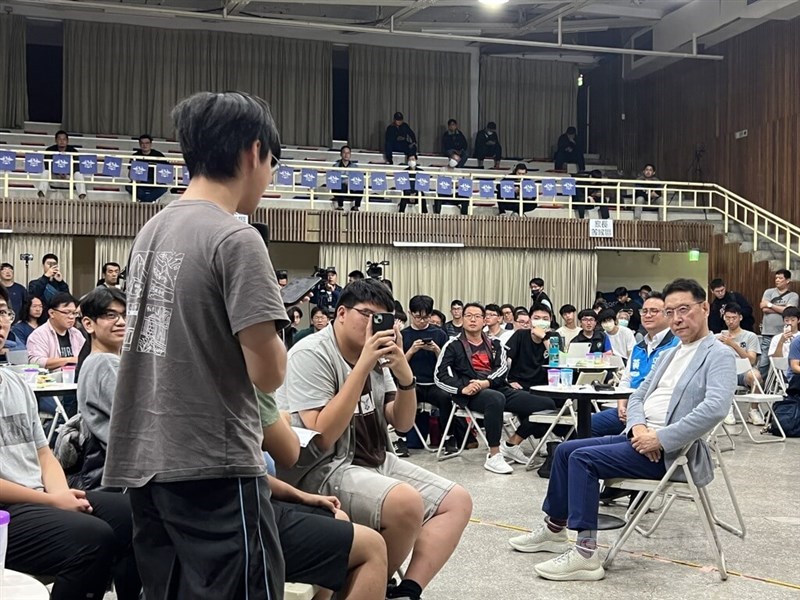 A student who takes part in Taichung First Senior High School asks his question to KMT vice presidential candidate Jaw Shau-Kong (right, in grey jacket) at a talk organized by the high school' student body on Saturday. CNA photo Dec. 9, 2023