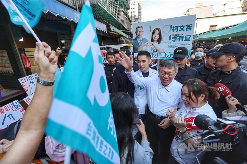 Taiwan People's Party Chairman and presidential candidate Ko Wen-je (center right) accompanies legislative candidate Lee Yo-yi (front, right) during their visit to a market in Luzhou District on Sunday.
