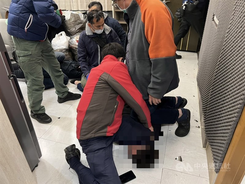 A suspect is pinned down by the police during a raid in Taichung on Dec. 25, 2022, where four victims are rescued. File photo courtesy of local authorities