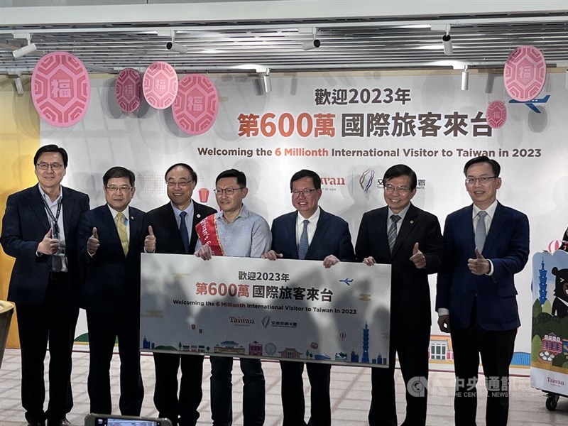 The 6 millionth visitor to Taiwan this year, who travels from Singapore (center) is pictured with Vice Premier Cheng Wen-tsan (third right) and Transportation Minister Wang Kwo-tsai (second right) at Taiwan Taoyuan International Airport on Friday. CNA photo Dec. 15, 2023
