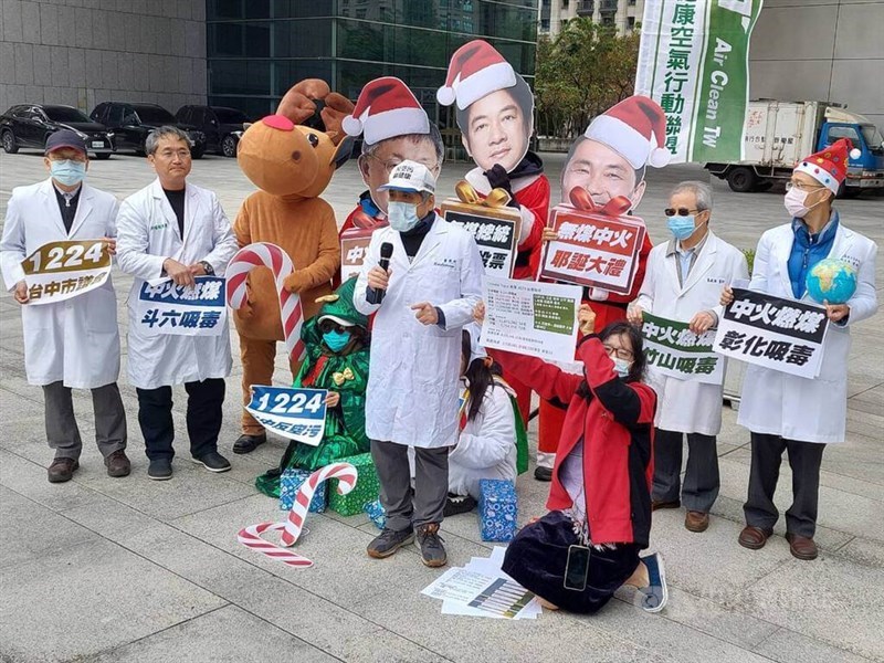 Yeh Guang-perng (front row second right), initiator of Air Clean Taiwan, and representatives from its member groups, gather in front of Taichung City Hall on Thursday with stands showing the three presidential candidates in Christmas costumes to announce an invitation for the three to attend the anti-air pollution rally scheduled on Sunday. CNA photo Dec. 21, 2023