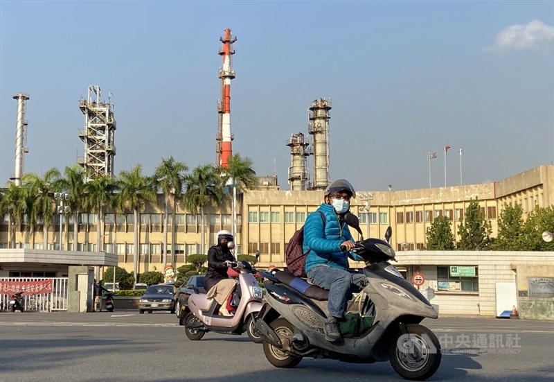Scooter riders travel past an oil refinery in Kaohsiung. CNA file photo