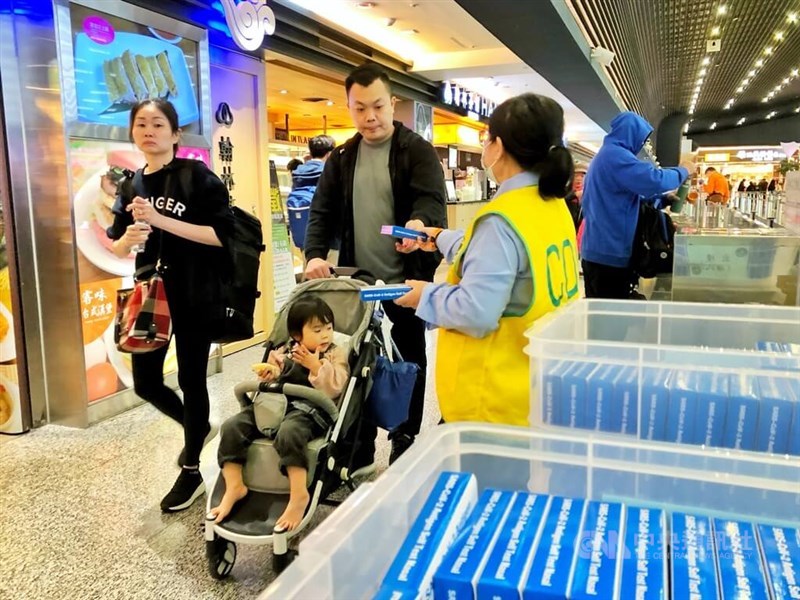 A CDC workers offers passengers free COVID-19 rapid test kits at Taiwan Taoyuan International Airport on Jan. 3, 2024. Photo: CNA