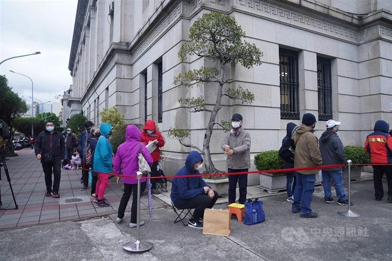 Members of the general public stay warm while waiting in line to get into Taiwan's central bank on Monday. CNA photo Jan. 22, 2024