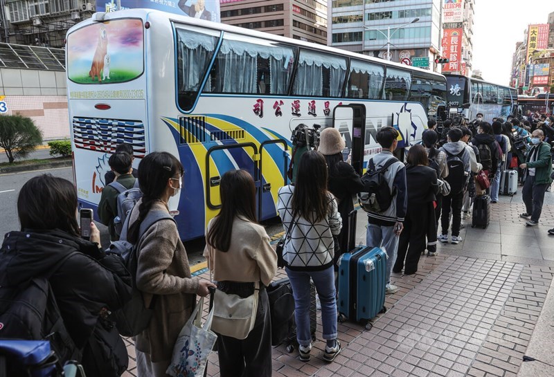 Young voters wait in lines to board buses chartered by the Taiwan Youth Association for Democracy, which provided cheaper fares to those who wished to travel back to their registered electoral districts during the Jan. 13 elections at Taipei Main Station, on Jan. 12, 2024. CNA file photo