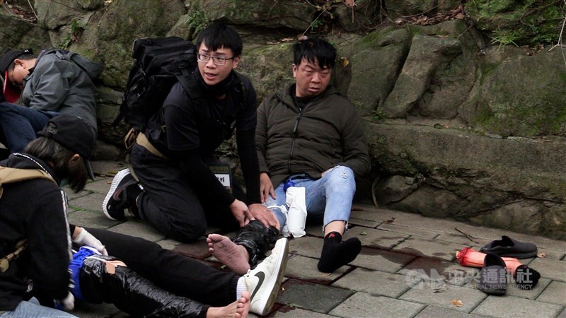 A drill participant provides first aid to another next to a fake severed leg to stimulate a real life wartime response situation in Taipei Saturday. CNA photo Jan. 27, 2024