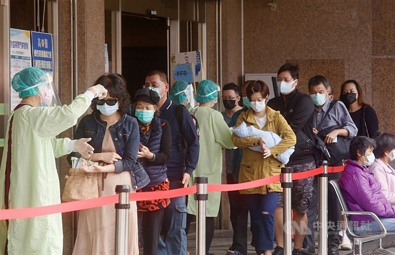 Nurses take temperatures from masked patients waiting to enter a hospital in this CNA file photo