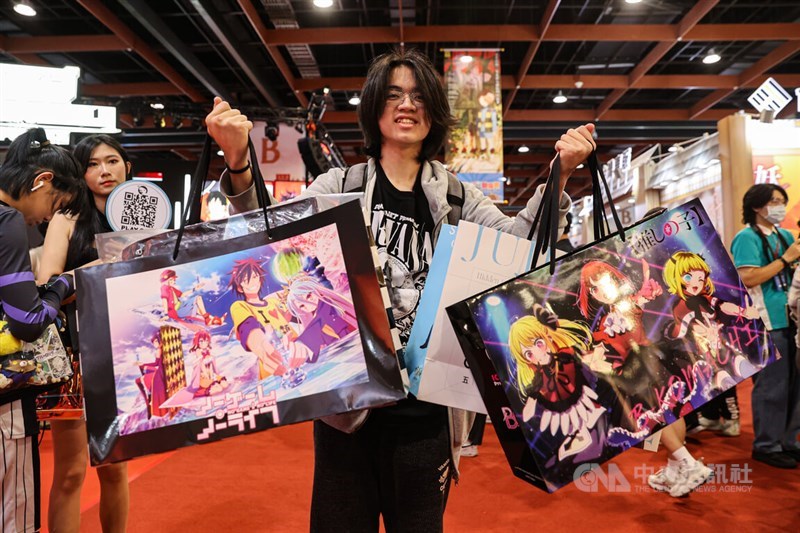 A comics fan displays his purchase at the Taipei International Comics and Animation Festival's opening day Thursday. CNA photo Feb. 1, 2024