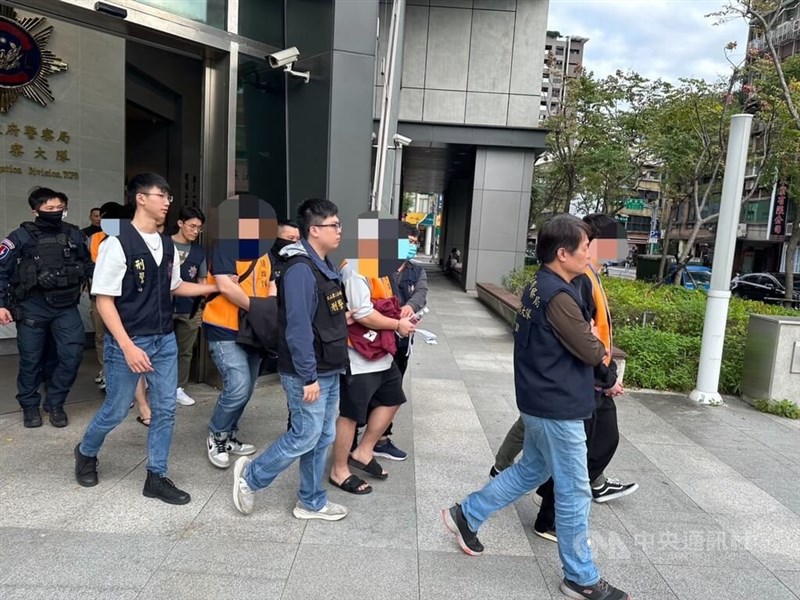 The 12 people in police custody over alleged cryptocurrency-related fraud are escorted by the law enforcement officers on their way to prosecutors office in Taipei in this undated photo released on Wednesday. Photo courtesy of local authorities Feb. 7, 2024