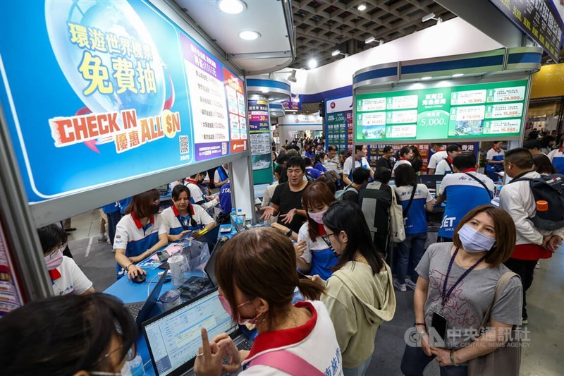 Visitors to the Taipei International Travel Fair check travel packages offered by travel agencies, which had no group trips to China on display, on Nov. 6, 2023. CNA file photo