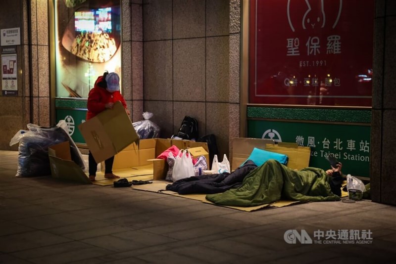 A homeless population make their beds outside of Taipei Main Station to get ready for bed. CNA photo Jan. 20, 2024