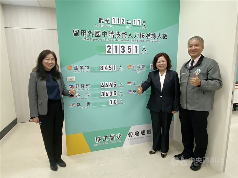 Labor Minister Hsu Ming-chun (second right) stands next to a board showing the number of skilled workers who obtained approval in the retention program in Hsinchu County on Dec. 6, 2023. CNA file photo