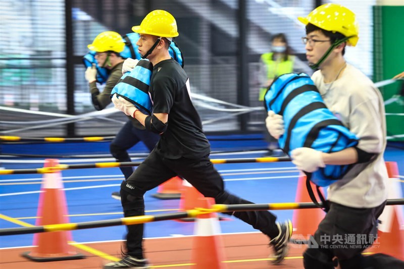 Male Taiwan Railway Corp. applicants participate in a 40 meters run while carrying heavy sandbags inside Taipei's Chihlee University of Technology, the northern examination location, on Sunday. CNA photo Feb. 18, 2024
