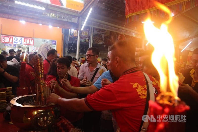 Worshippers light incense sticks to pray to the Jade Emperor on Saturday night at 10 o'clock, an auspicious hour. CNA photo Feb. 18, 2024