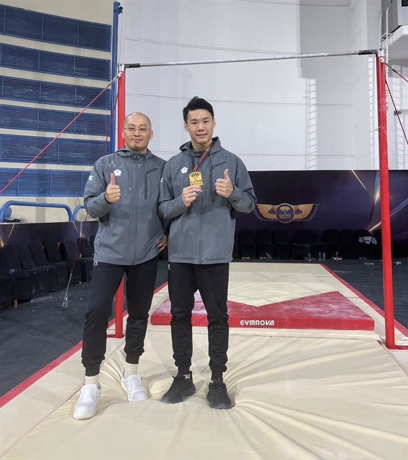 Taiwanese gymnast Tang Chia-hung (right) shows the gold medal he wins at the 2024 Apparatus World Cup series in Cairo with his coach Weng Shih-hang on Sunday. Photo courtesy Weng Shih-hang