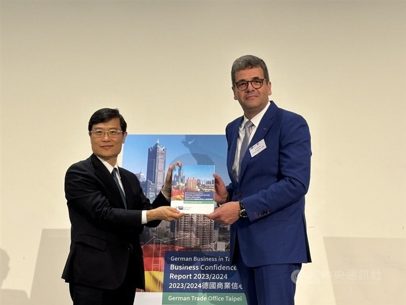 Axel Limberg (right), who heads the German Trade Office in Taipei, hands a copy of the "German Business Confidence Survey Report 2023/2024" to Deputy Economics Minister Chen Chern-chyi at the report releasing event in Taipei on Thursday. CNA photo Feb. 22, 2024