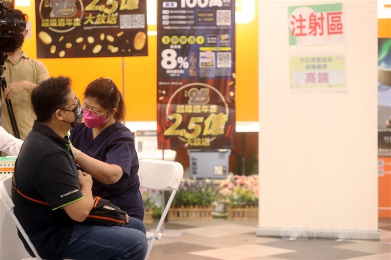 A health worker administers a flu vaccine shot to a man at a supermarket in Taipei on Nov. 1, 2023, when the free vaccine became available to people aged 50 and above. CNA file photo