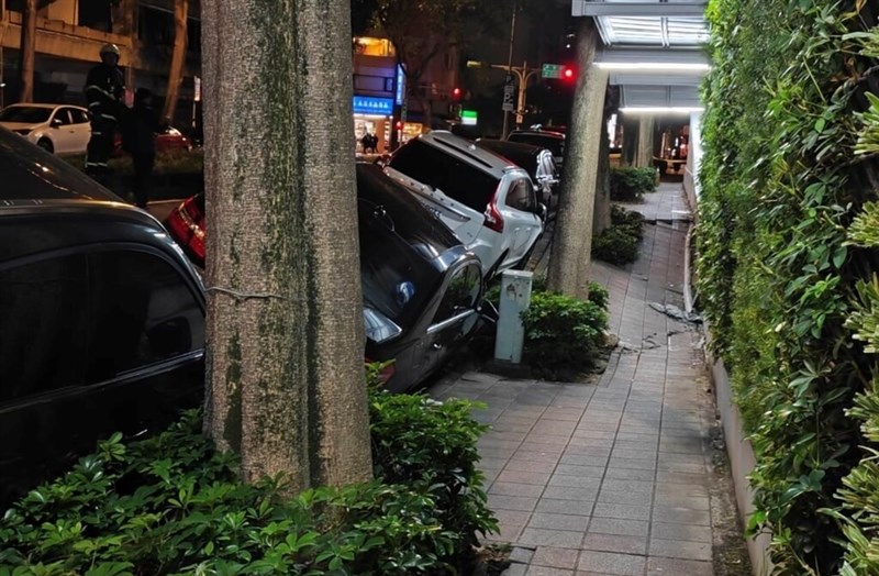 Four parked cars sink on a section of a road in Taipei's Songshan District on Friday night, due to a fault at a nearby construction site, according to the city government. Photo provided by local authorities