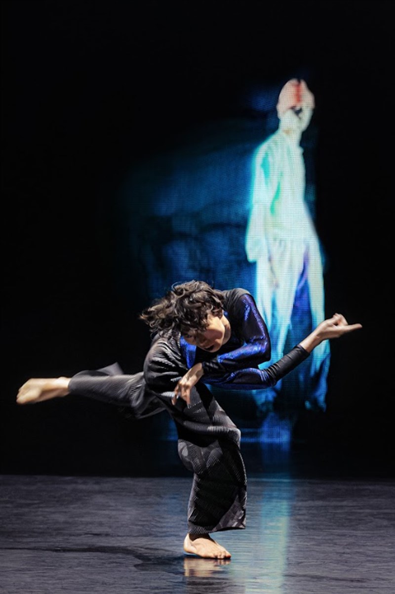 A dancer performs against the backdrop of a screen showing an AI-generated image in "Waves." Photo courtesy of Cloud Gate Dance Theatre