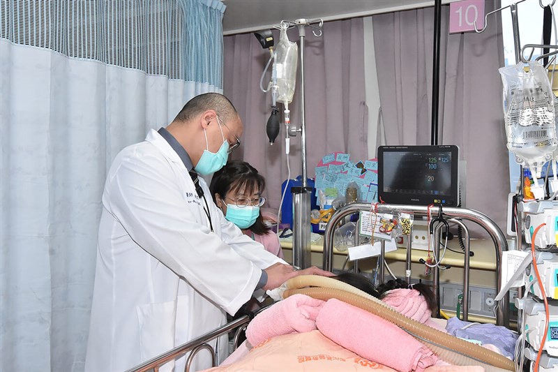 A doctor checks on the 8-year-old middle sister of the three young siblings in Changhua County last week. Photo courtesy of Changhua Christian Hospital