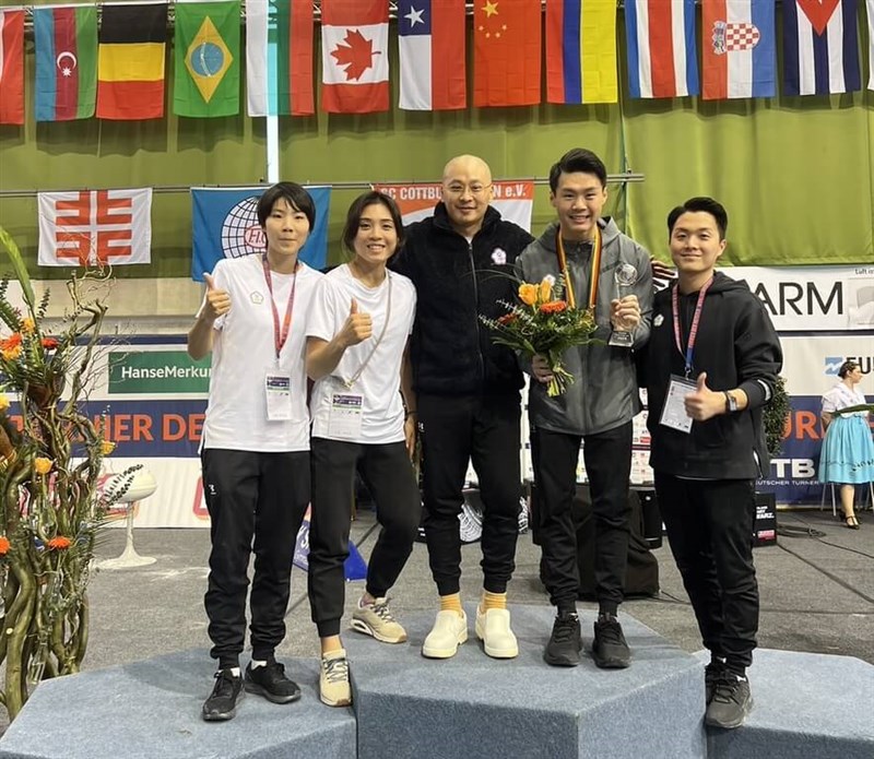 Horizontal bar standout Tang Chia-hung (second right) poses with his team after the athlete's gold-medal win on Sunday. Photo courtesy of Weng Shih-hang Feb. 26, 2024