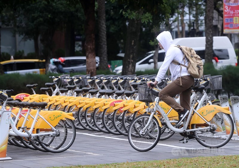 A commuter rides his YouBike by a parking station in Taipei on Tuesday. CNA photo Feb. 27, 2024