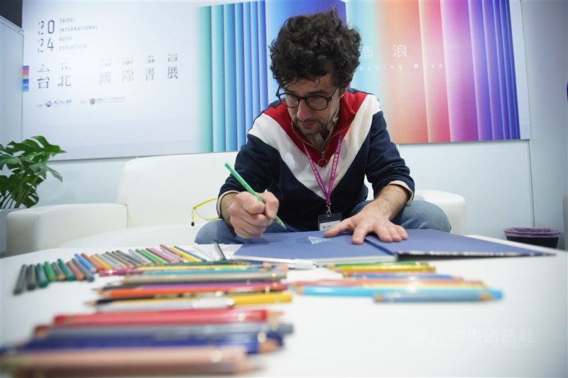 French illustrator Florent Chavouet signs a copy of his L'ile Louvre at the Taipei International Book Exhibition on Feb. 23. CNA file photo