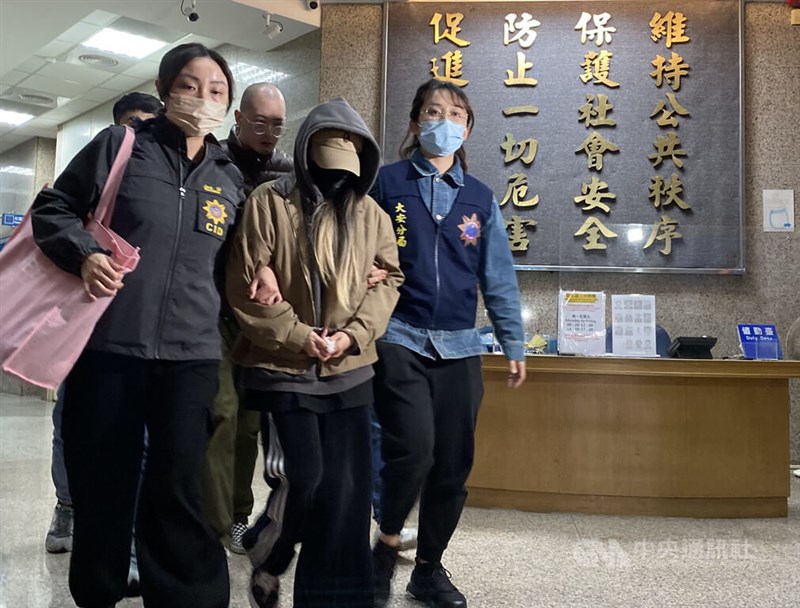 A Taipei City government employee (in hooded jacket) is escorted by police on their way to the Taipei District Prosecutors Office Wednesday. CNA photo March 6, 2024