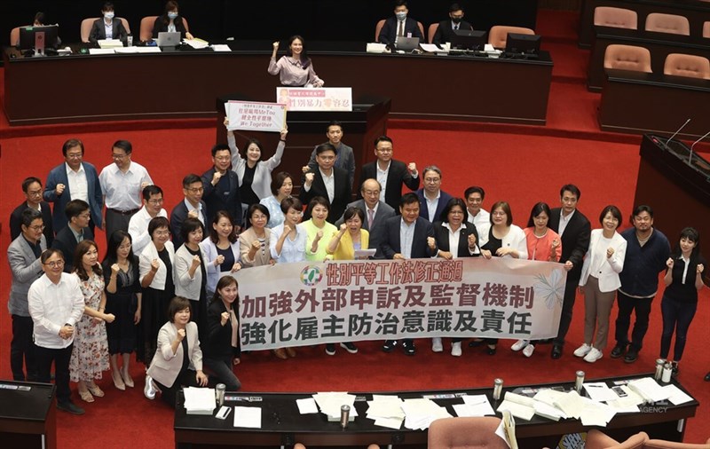 Lawmakers hold a banner to celebrate the passing of amendments to three gender equality acts on July 31, 2023. CNA file photo