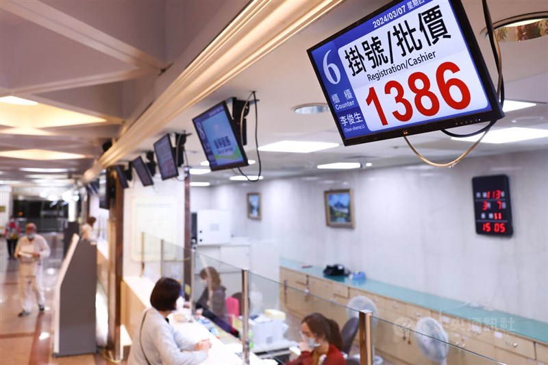 A woman speaks with a hospital staff at the registration/cashier counter at Taipei City Hospital's Ren'ai Branch on Thursday. CNA photo March 7, 2024