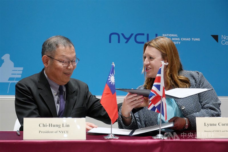 NYCU President Lin Chi-hung (left) and NICA Deputy Director Lynne Corner exchange packs at a press conference in Taipei Tuesday. CNA photo March 19, 2024