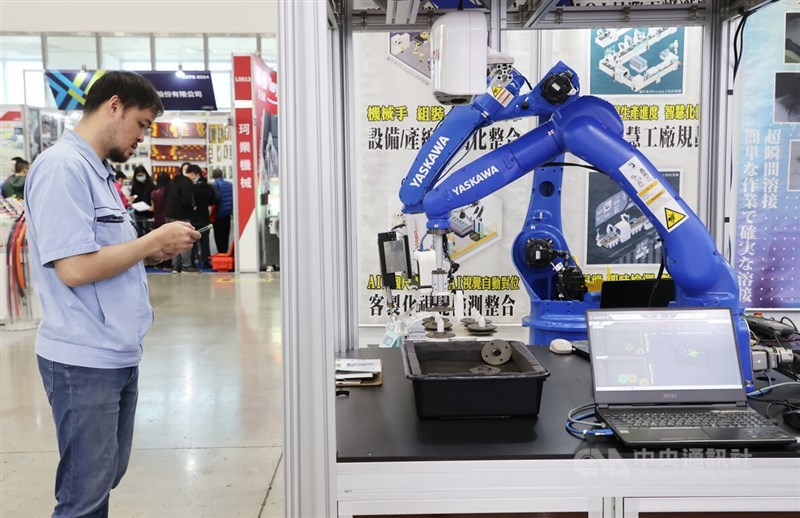 A visitor stands in front of robotic arms at the Taiwan International Machine Tool Show in Taipei Nangang Exhibition Center on Thursday. CNA photo March 28, 2024