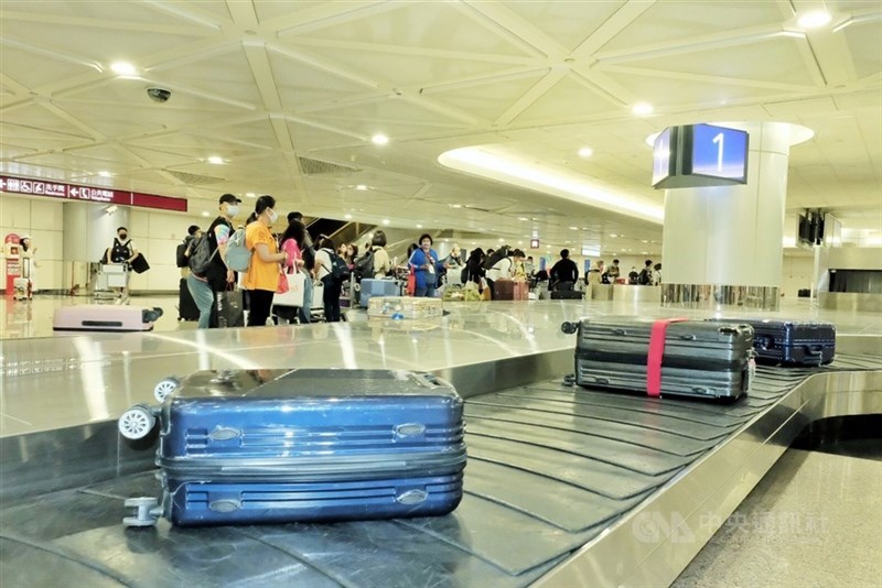 Arrival passengers wait at the baggage claim area in Taoyuan Airport in this CNA file photo