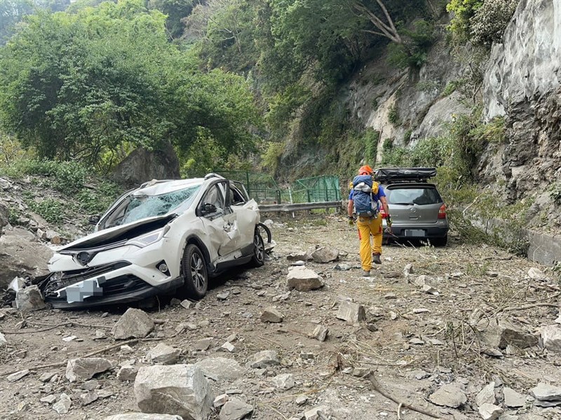 A search and rescue team member walks by vehicles hit by falling rocks along the Provincial Highway No. 8 in central Taiwan in this photo released on Sunday. Photo courtesy of Hualien County Fire Department April 7, 2024