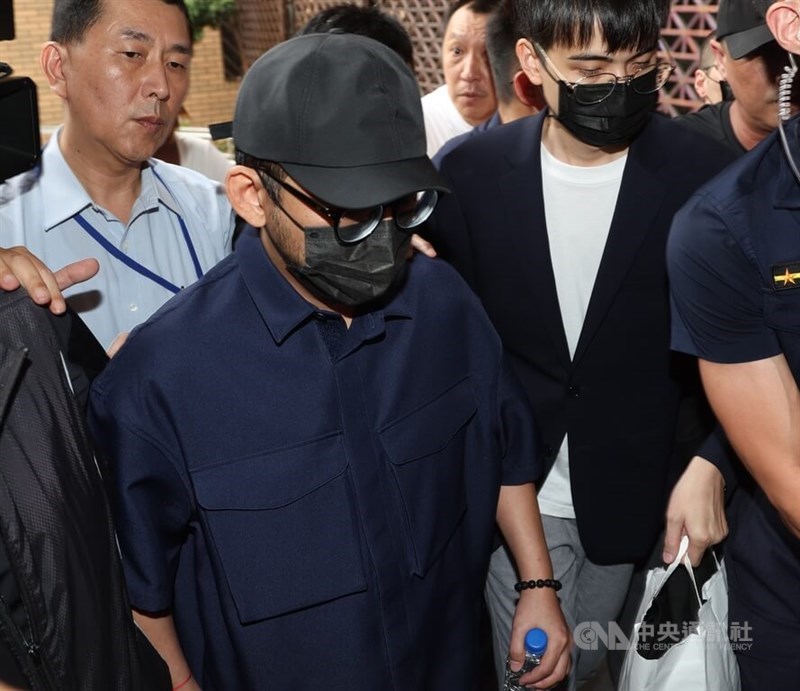 TV host Mickey Huang (in dark blur shirt) is brought to the Taipei Prosecutors Office on Aug. 4, 2023 for questioning. CNA file photo