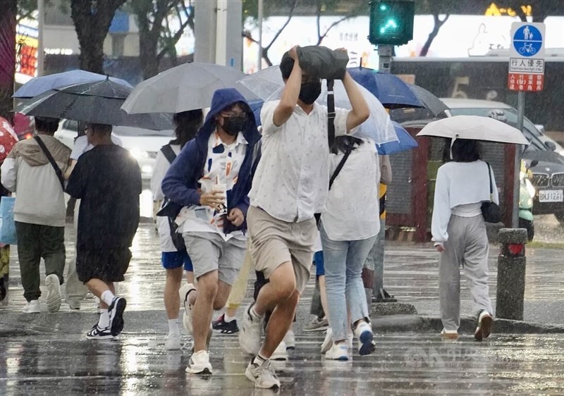 Pedestrians in Kaohsiung run across a road in the rain in Kaohsiung Wednesday. CNA photo April 24, 2024