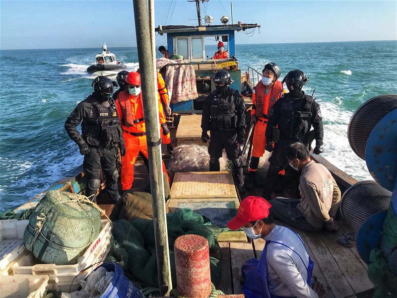 Coast Guard officers (in black and orange) are onboard a Chinese fishing boat that entered the water around Taiwan-controlled Kinmen Islands in 2020. File photo courtesy of Coast Guard Administration's Kinmen unit