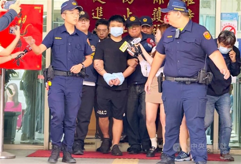 The main suspect (center, in black) in the alleged triple homicide in New Taipei is escorted by the police before he was handed over the the prosecutors on Monday. CNA photo May 13, 2024