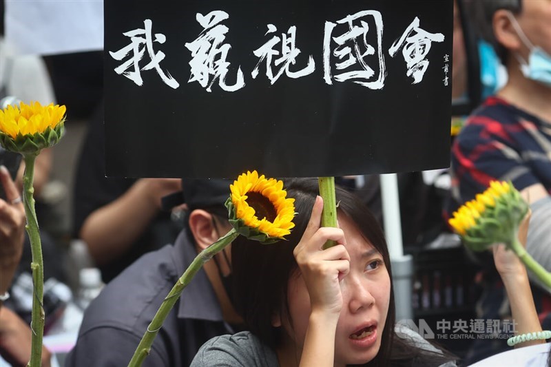 A protester holds a sign that reads "I'm in contempt of congress" outside the Legislature on Tuesday to call for more transparency regarding the controversial "legislative reform bills." CNA photo May 21, 2024
