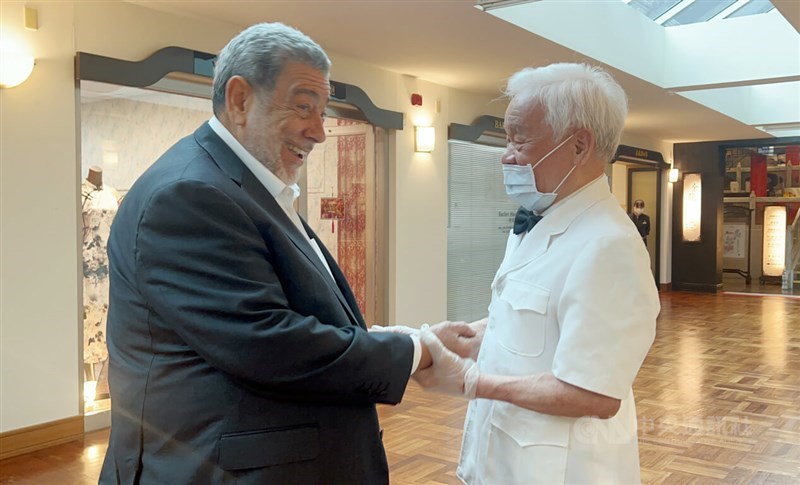 周二，圣文森特和格林纳丁斯总理拉尔夫·贡萨尔维斯（左）和台湾理发师邱延中在台北相互问候。CNA照片2024年5月22日