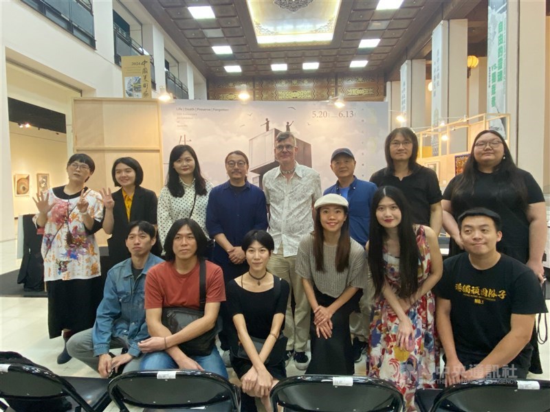 Curators and featured artists of the art exhibition titled "Life Death Preserve Forgotten" take a group photo at the exhibition venue at Chiang Kai-shek Memorial Hall Sunday. CNA photo June 2, 2024