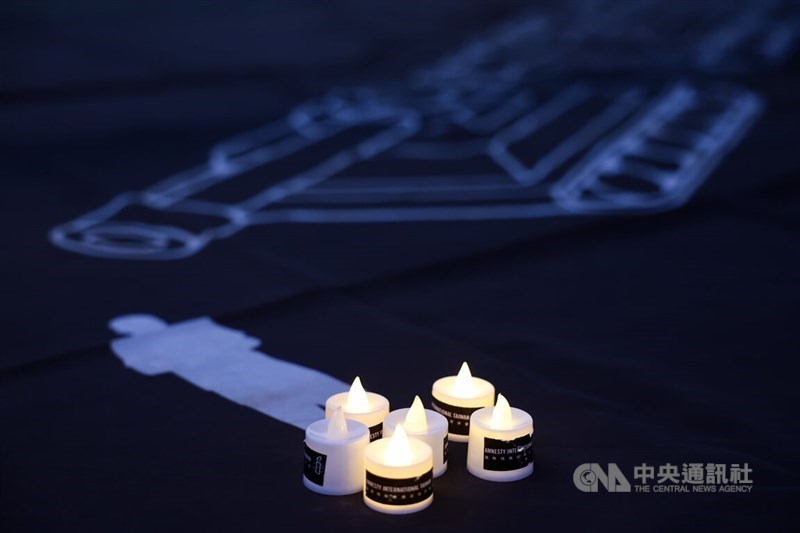 Lit candles are placed at a commemorative event for the June 4th Incident on Tuesday, near a painting of a man standing in front of tanks. The painting serves as a tribute to the "Tank Man," an unidentified individual who stood in front of a column of tanks leaving Tiananmen Square on June 5, 1989. CNA photo June 4, 2024