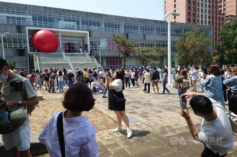 Visitors to National Cheng Kung University in Tainan take photos of American artist Kurt Perschke's red ball displayed at the school's Future Venue on April 1, 2024. CNA file photo