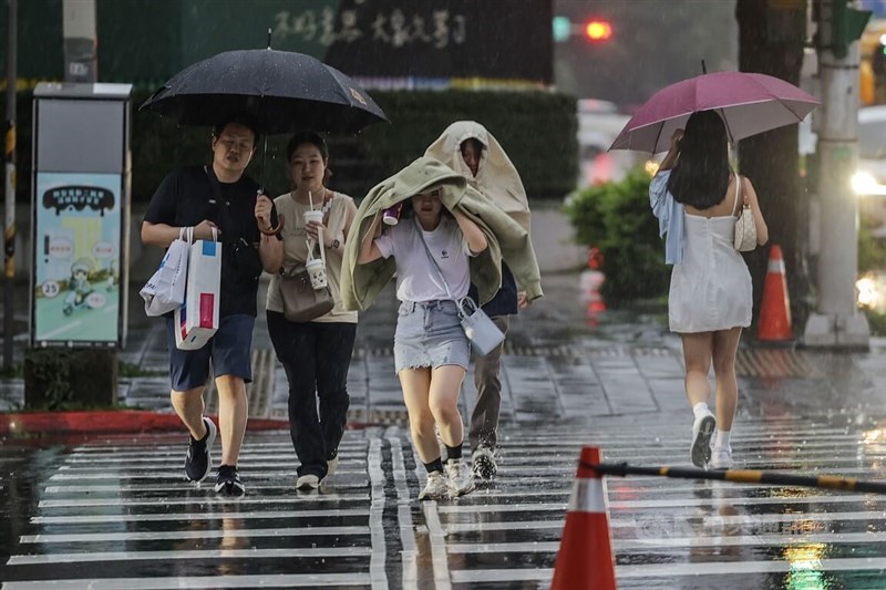 Taipei pedestrians cross the street in the rain on Sunday afternoon. June 16, 2024