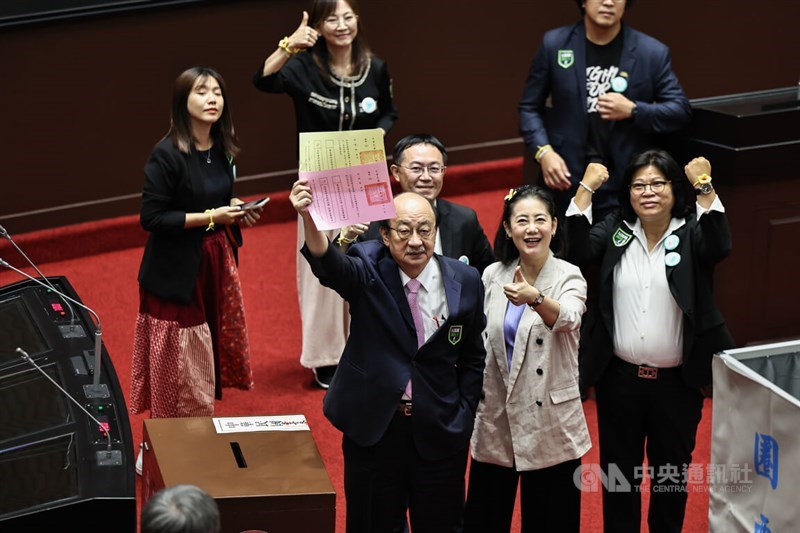 DPP caucus whip Ker Chien-ming (front left) shows his vote Friday. CNA photo June 21, 2024