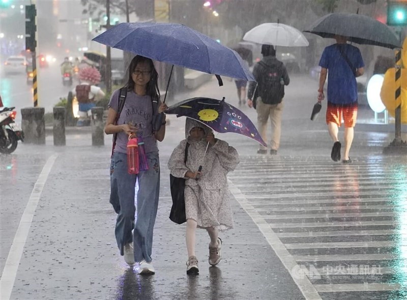 Pedestrians cross a street amid rainy weather in Taipe. CNA file photo