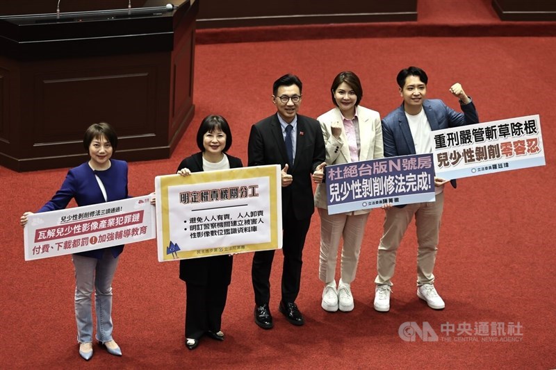 Deputy Legislative Speaker Johnny Chiang (center) and legislators pose for a photo at the Legislative Yuan early Saturday, after amendments to the Child and Youth Sexual Exploitation Prevention Act were approved. CNA photo July 13, 2024