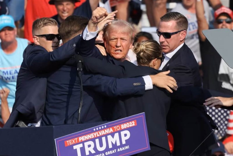 Republican presidential candidate and former U.S. President Donald Trump is assisted by security personnel after gunfire rang out during a campaign rally at the Butler Farm Show in Butler, Pennsylvania, U.S., July 13, 2024. Photo: Reuters