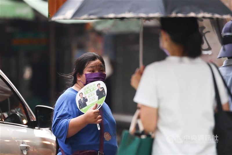 A woman in New Taipei's Tucheng District uses a hand fan to stay cool amid scorching weather in this undated photo. CNA file photo